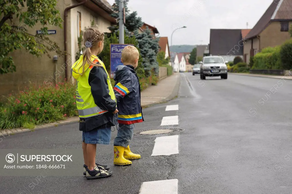 Two children, 3 and 7 years, waiting to cross the street, Assamstadt, Baden-Wuerttemberg, Germany, Europe