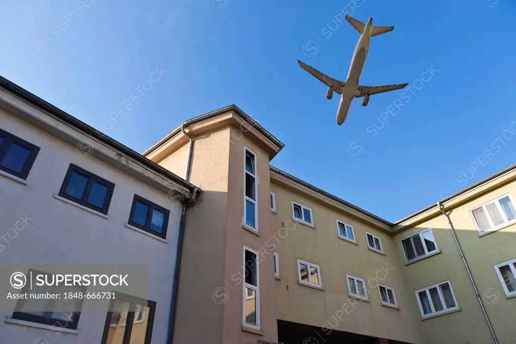 Aircraft flying over residential buildings, aircraft noise in residential areas, digital composing, Frankfurt, Hesse, Germany, Europe, PublicGround