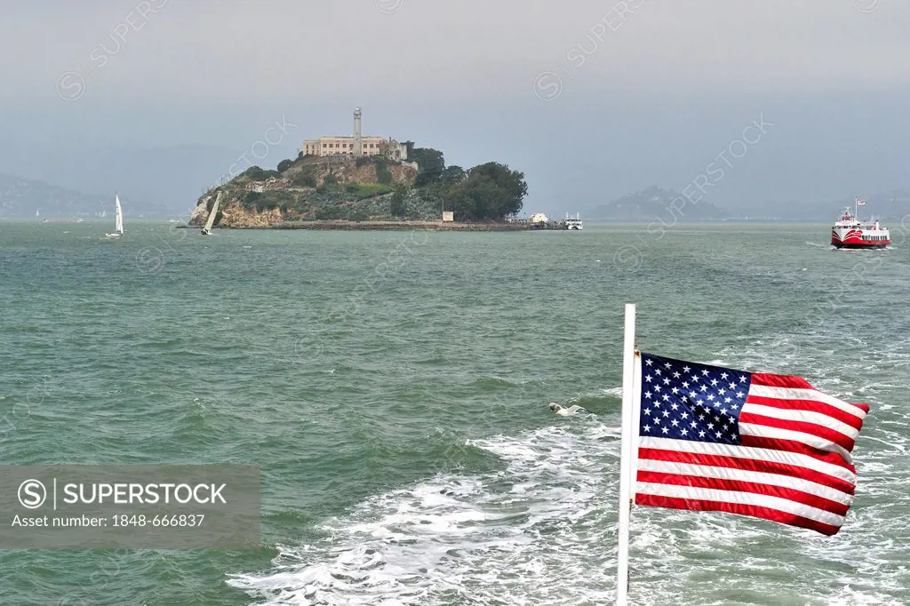 Alcatraz Island as seen from a ferry with an American flag, San Francisco, California, USA