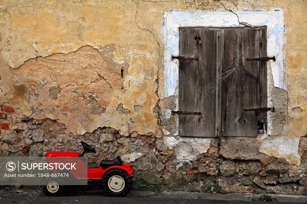 Old window with a red toy tractor parked outside, at the old Hackermuehle or Obermuehle, mill, 1547, Obertrubach, Upper Franconia, Bavaria, Germany, E...