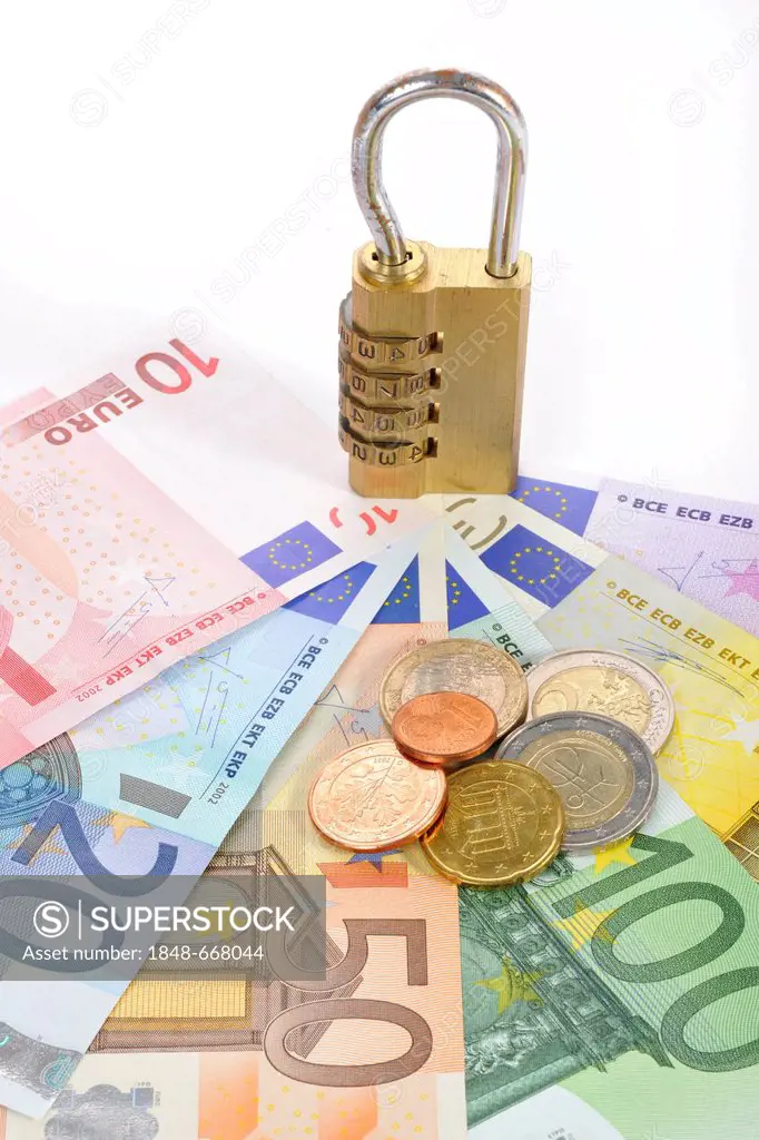 Combination lock on euro banknotes and coins, symbolic image of monetary security