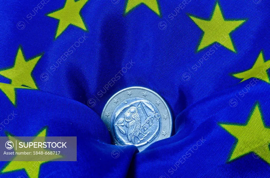Greek euro coin lying on an European flag, going down, symbolic image