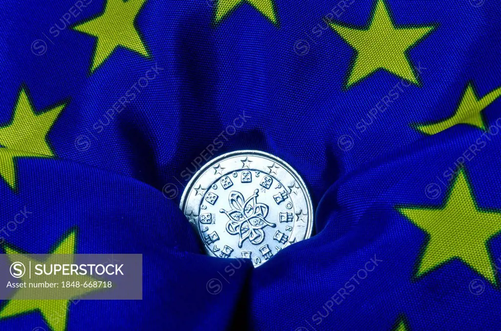 Portuguese euro coin lying on an European flag, going down, symbolic image