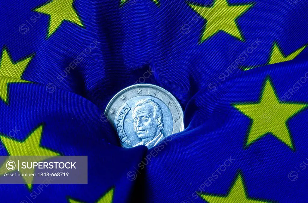 Spanish euro coin lying on an European flag, going down, symbolic image