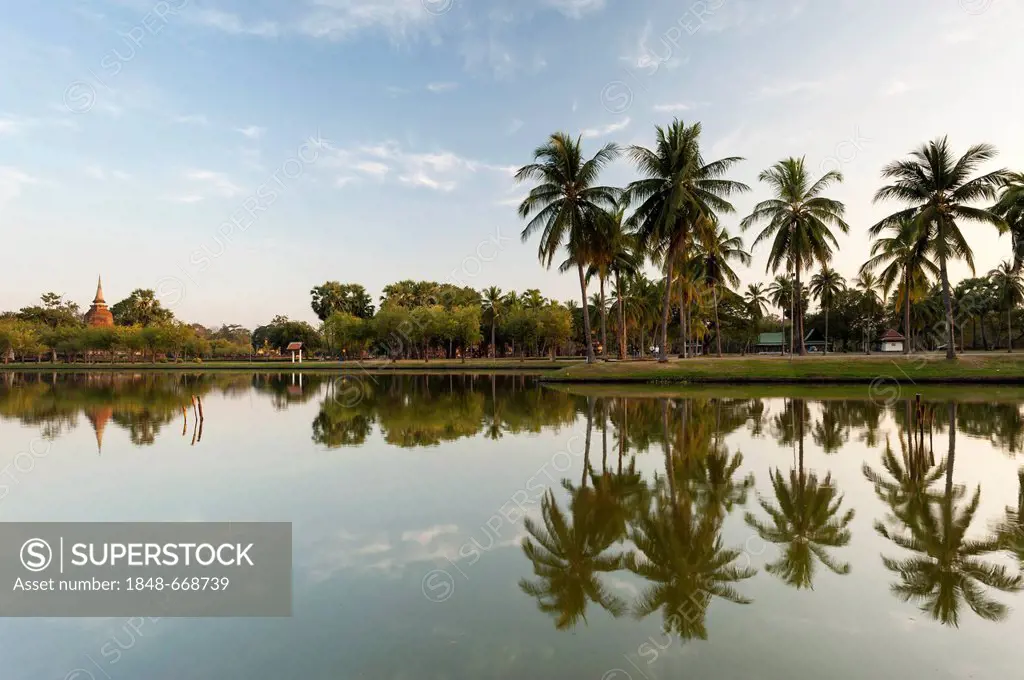 Chedi with palm trees and reflection in water, Wat Sa Si or Sra Sri temple, Sukhothai Historical Park, UNESCO World Heritage Site, Northern Thailand, ...