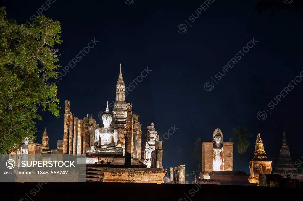 Seated and standing Buddha statues at Wat Mahathat temple, at night, Sukhothai Historical Park, UNESCO World Heritage Site, Northern Thailand, Thailan...