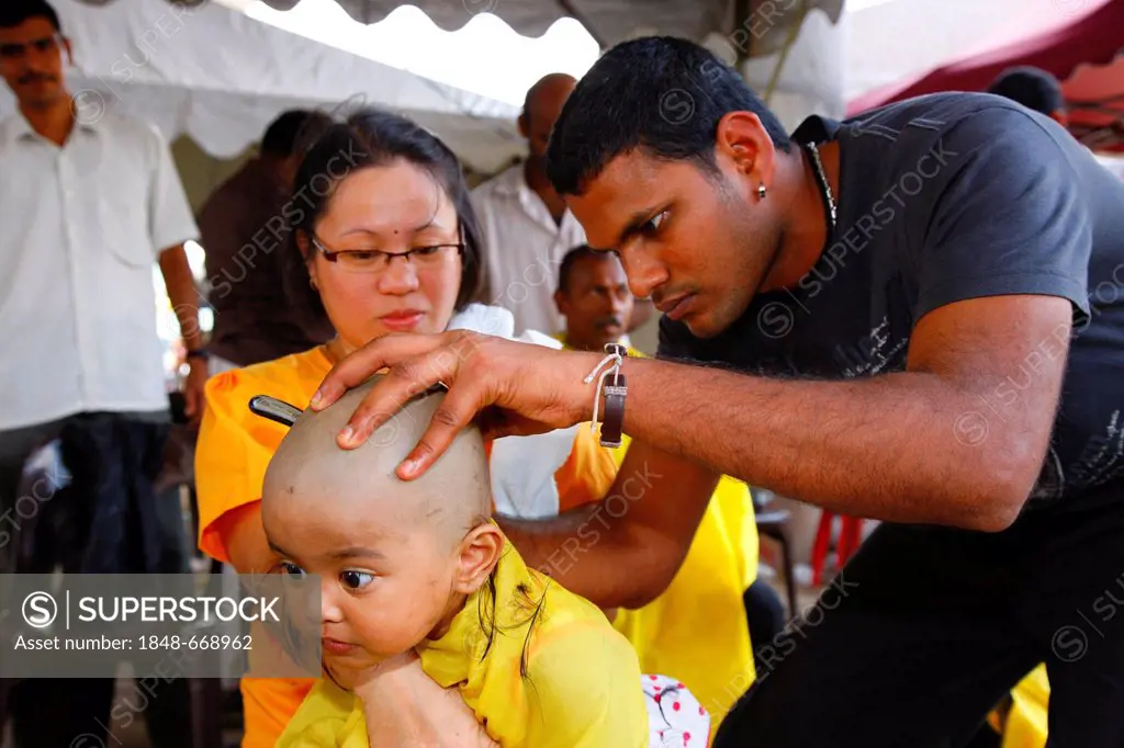 Child's hair being shaved with a razor, Hindu festival Thaipusam, Batu Caves limestone caves and temples, Kuala Lumpur, Malaysia, Southeast Asia, Asia