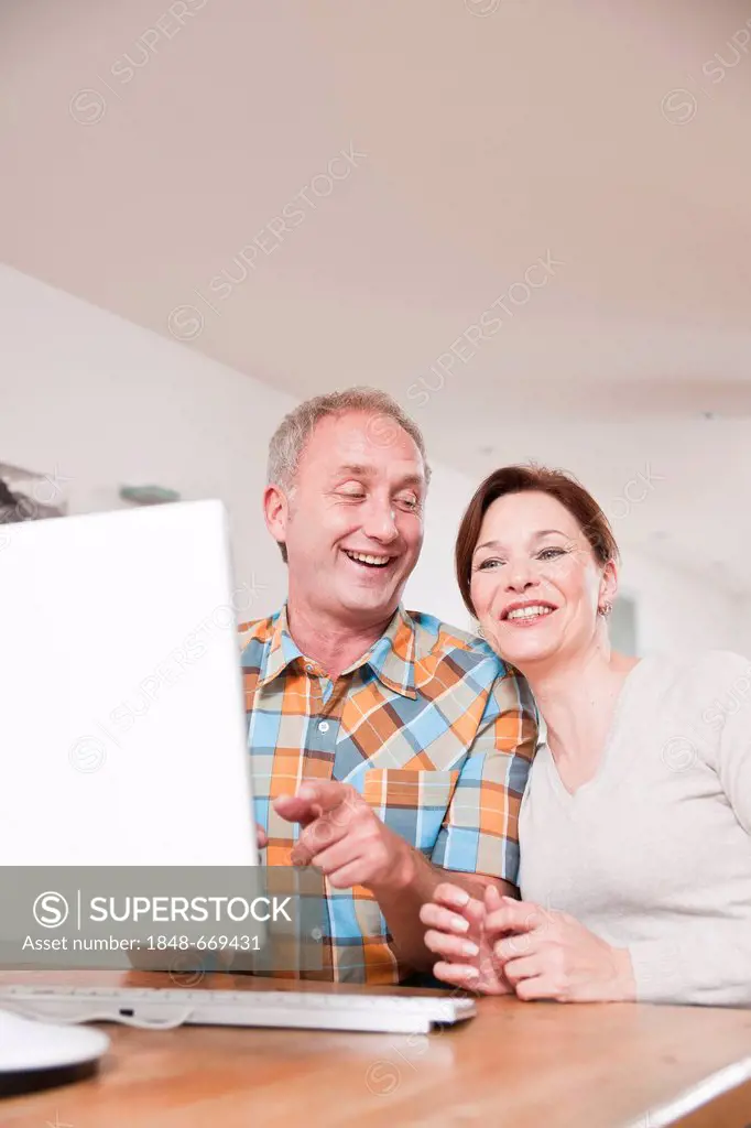 Smiling couple sitting in front of a computer