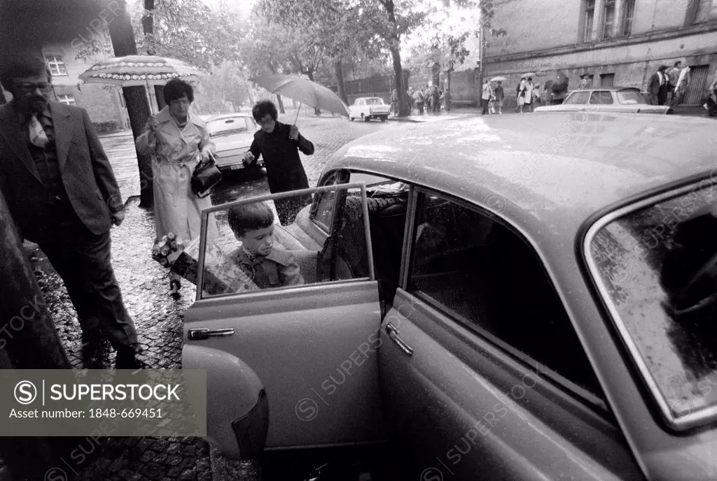 Child with a school cone getting into a Wartburg 311 car, Leipzig, East Germany, historical photograph around 1978