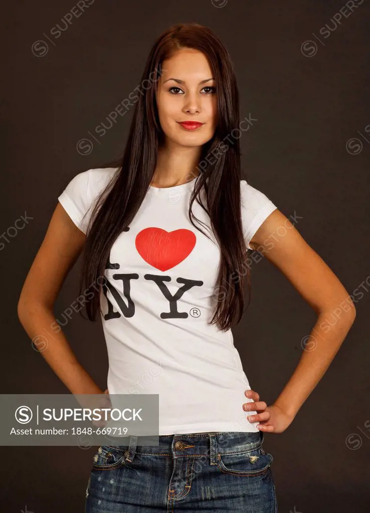 Self-confident young woman posing in a white T-shirt, lettering I love NY