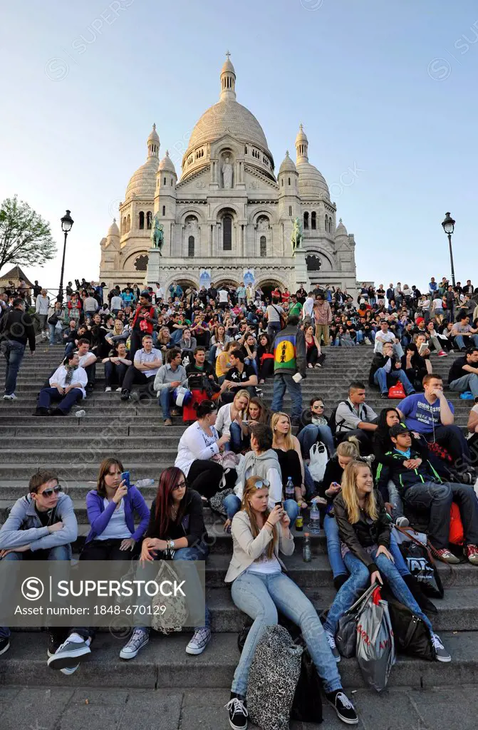 Tourists on steps in front of the Basilica of the Sacred Heart of Paris or Sacré-Cur Basilica, Montmartre, Paris, France, Europe