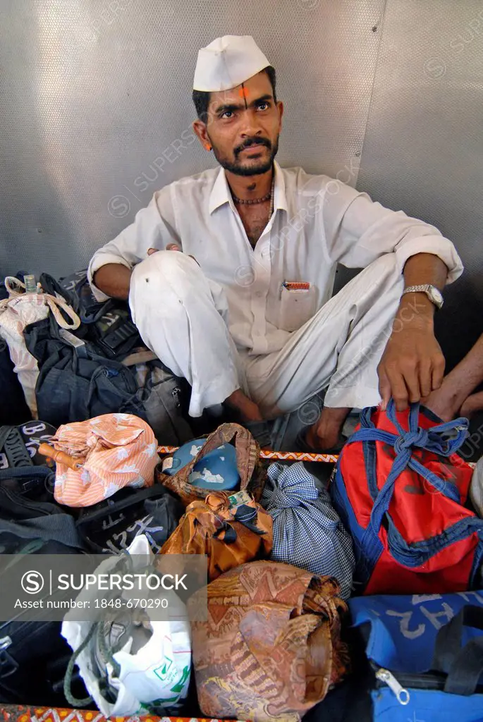 Dabba wallah or food deliverer with Dabbas or food containers in a local train, Mumbai, India, Asia