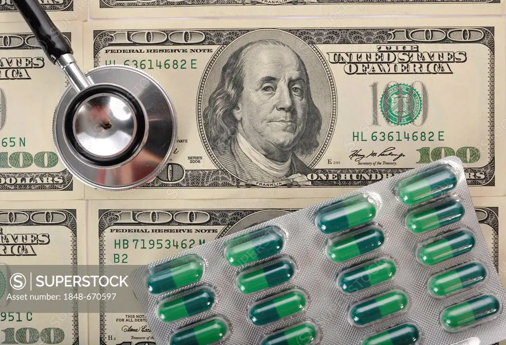 Stethoscope and capsules on U.S. dollar banknotes, symbolic image of a sick U.S. currency or the increasing cost of health care