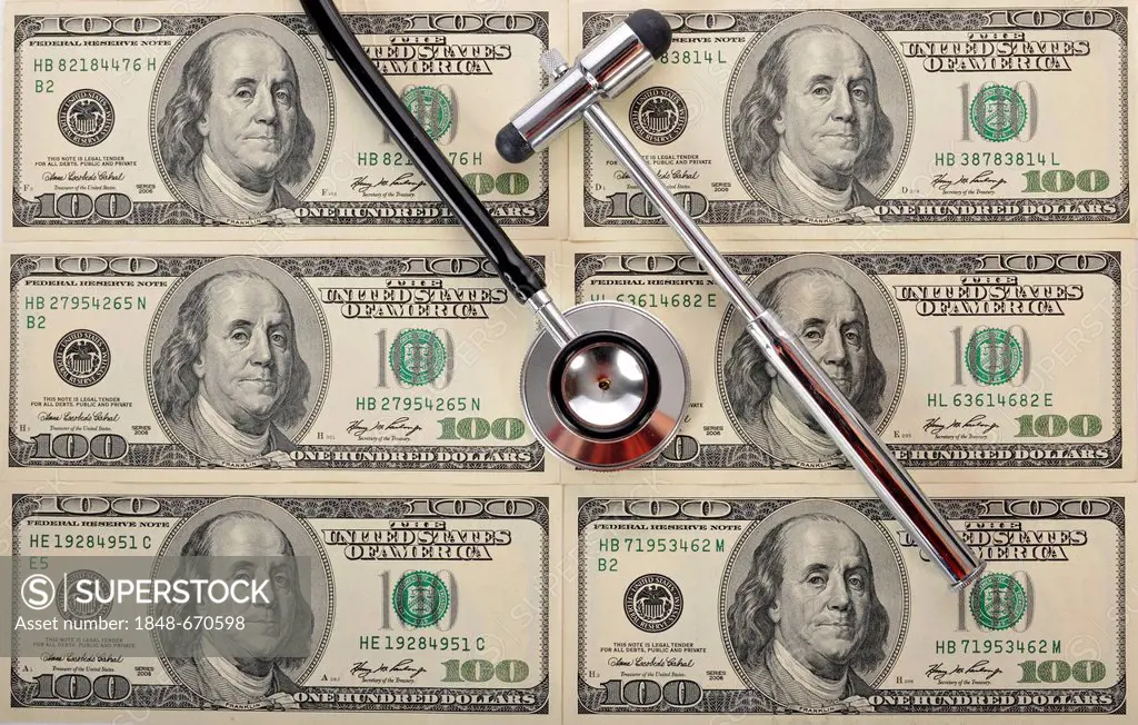 Stethoscope and a reflex hammer on U.S. dollar banknotes, symbolic image of a sick U.S. currency or the increasing cost of health care