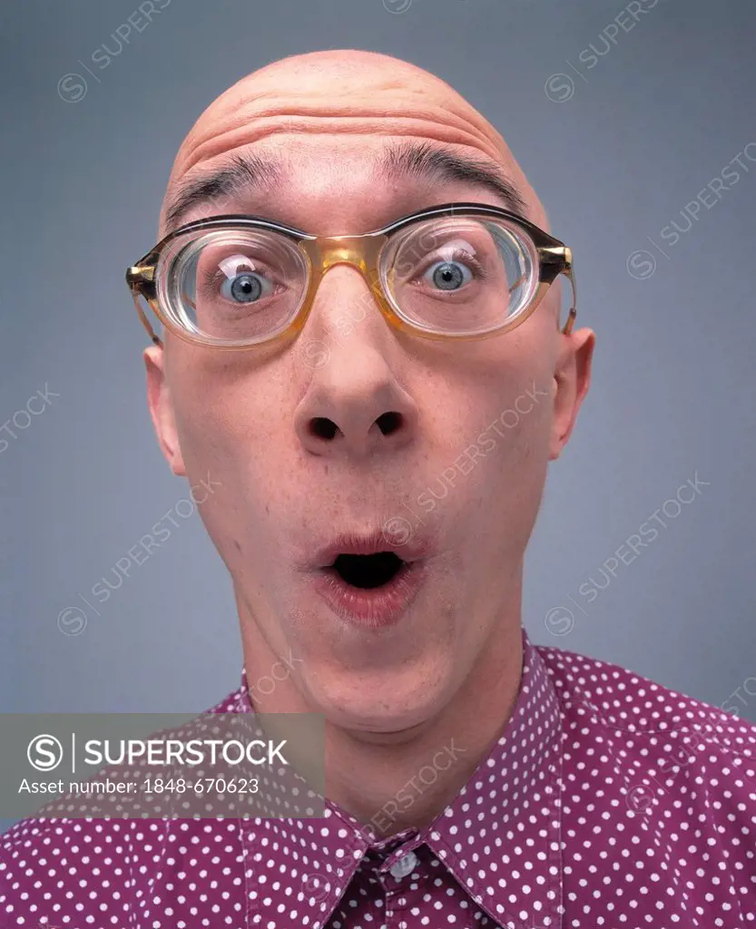Baldheaded man wearing glasses with a surprised face
