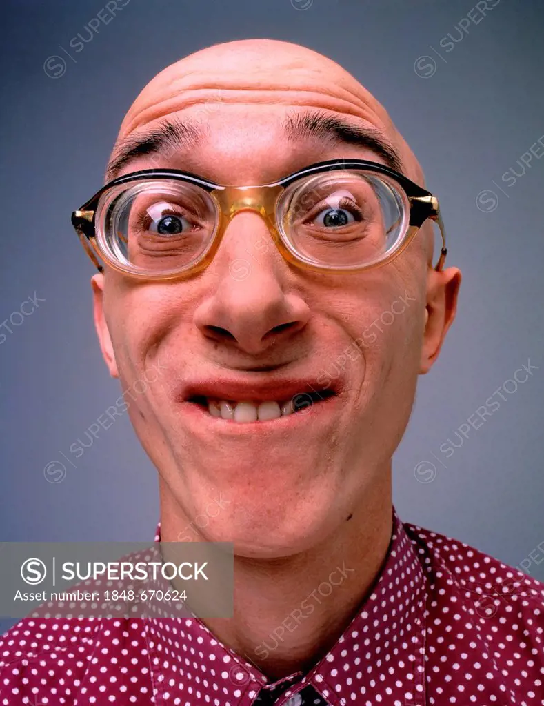 Baldheaded man wearing glasses, grimacing