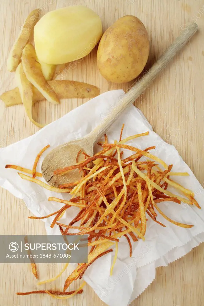 Potato straws, Pommes pailles, or matchstick potatoes, Pommes allumettes, wooden spoon, peeled and unpeeled potato