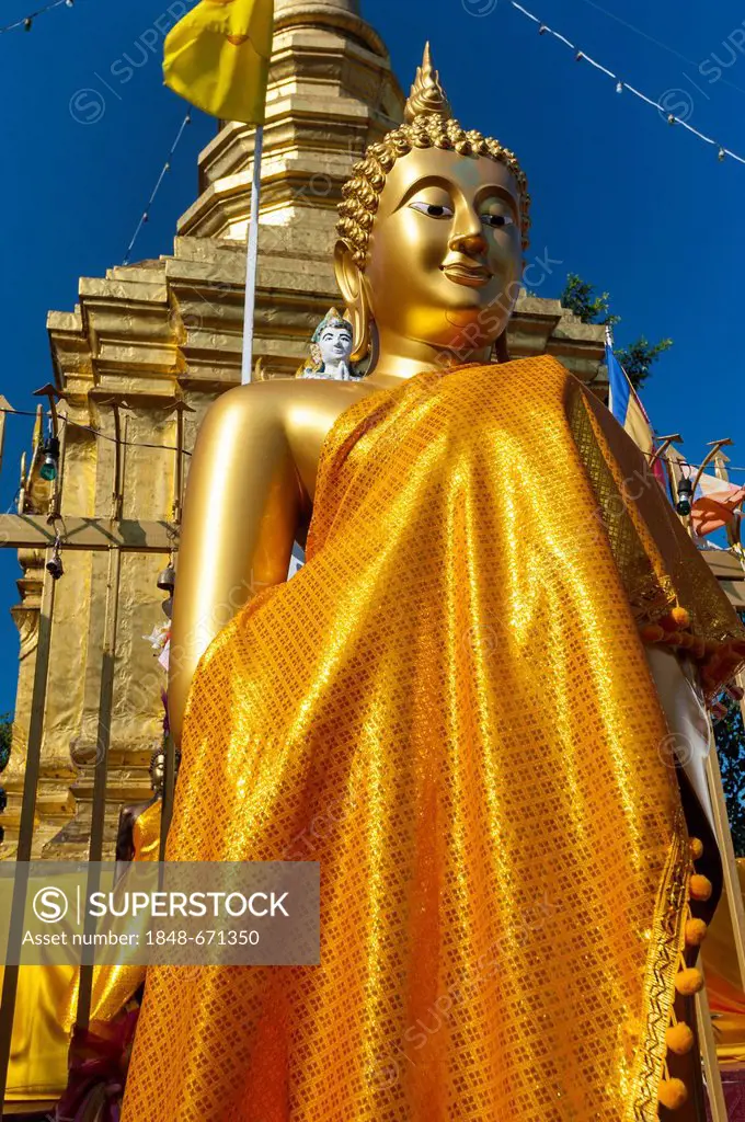 Upright golden Buddha statue in front of the golden pagoda or Chedi, Wat Phra That Doi Wao Temple in Mae Sai, the northernmost town in Thailand, North...