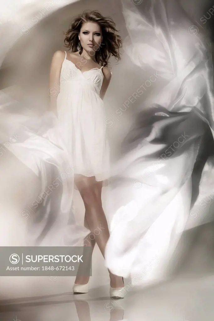 Young woman wearing a white dress with billowing fabric, fashion