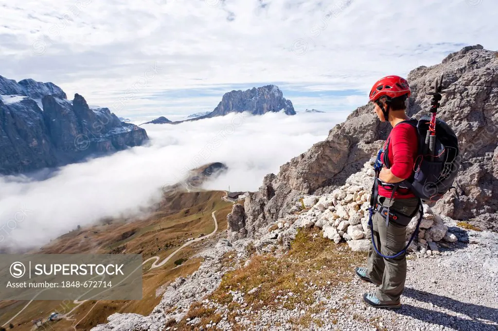 Climber on the way up to Gran Cir mountain above the Gardena Pass, Dolomites, Val Gardena valley and Langkofel mountain at the back, province of Bolza...