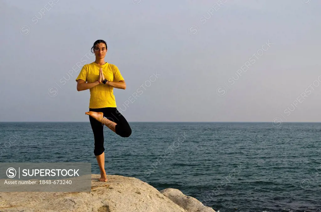 Woman in a yoga position, Vrikshasana, by the sea in Kanyakumari, Tamil Nadu, India, Asia