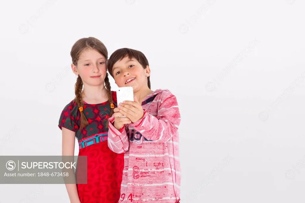 Girl and boy, 9 years, with mobile phone