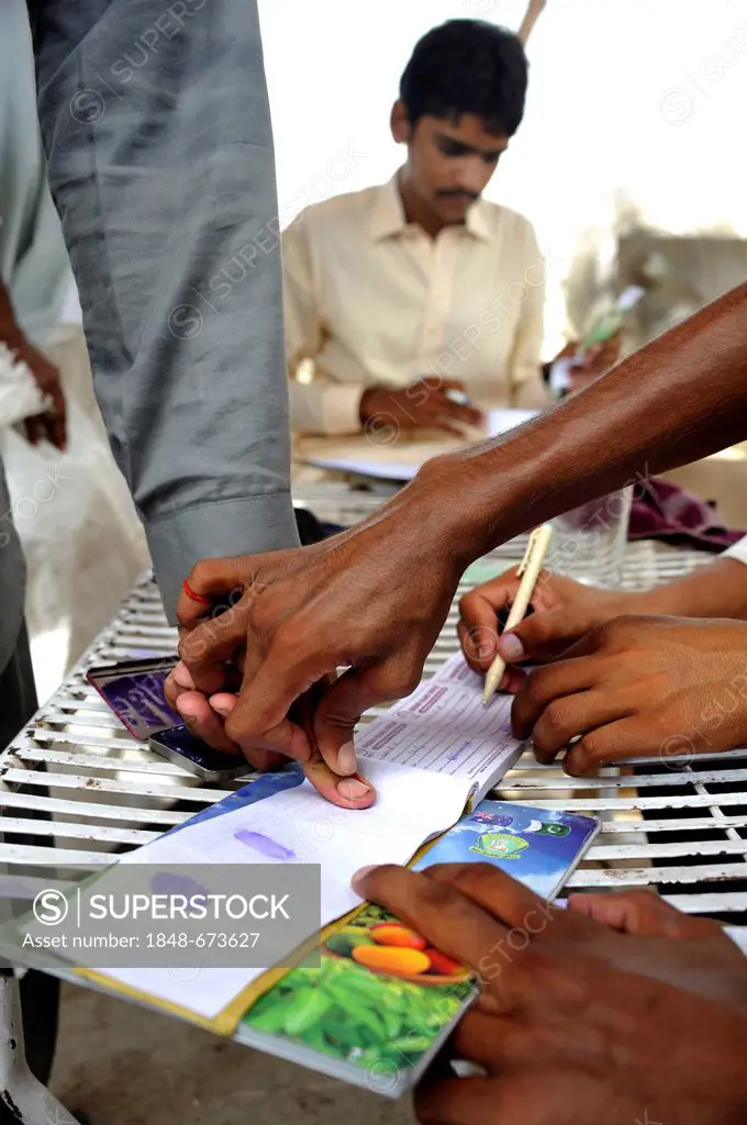 Distribution by a charity organisation after the flood disaster in 2010, beneficiaries signing with their fingerprint, Muzaffaragarh, Punjab, Pakistan...