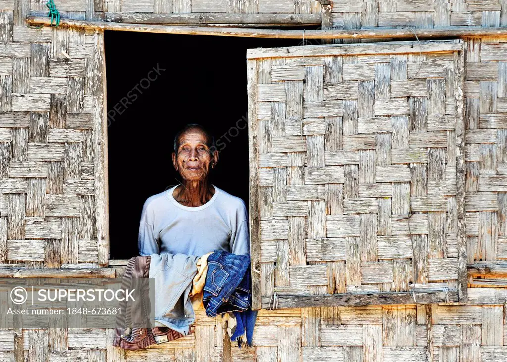Man in the window of a bamboo hut, Laos, Southeast Asia, Asia