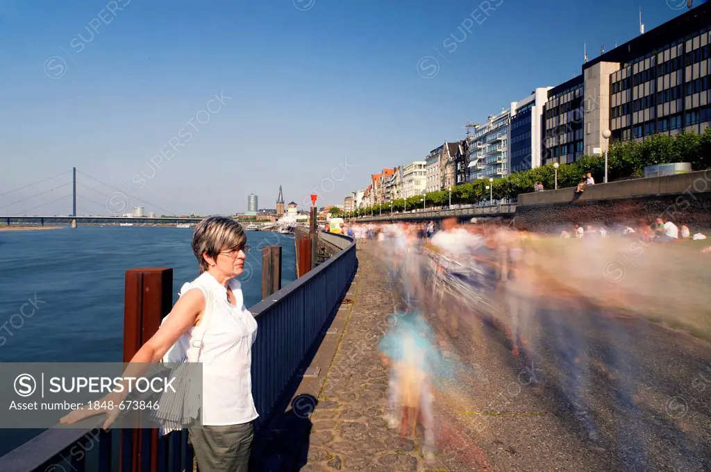 Woman standing at the rails on the banks of the river Rhine, Duesseldorf, North Rhine-Westphalia, Germany, Europe