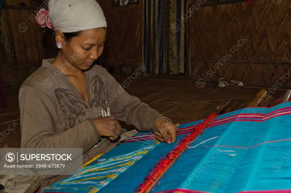 Adi Gallo woman weaving material at a traditional hand loom in Pobdi village, Arunachal Pradesh, India, Asia