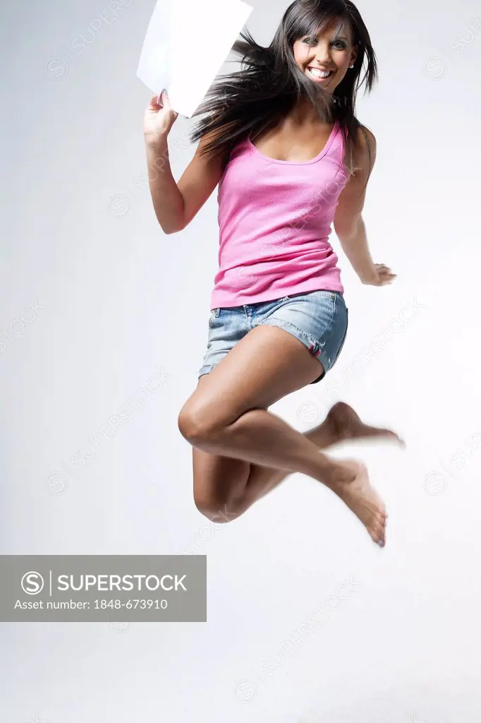 Young woman jumping in the air with joy, pleased about passing an examination