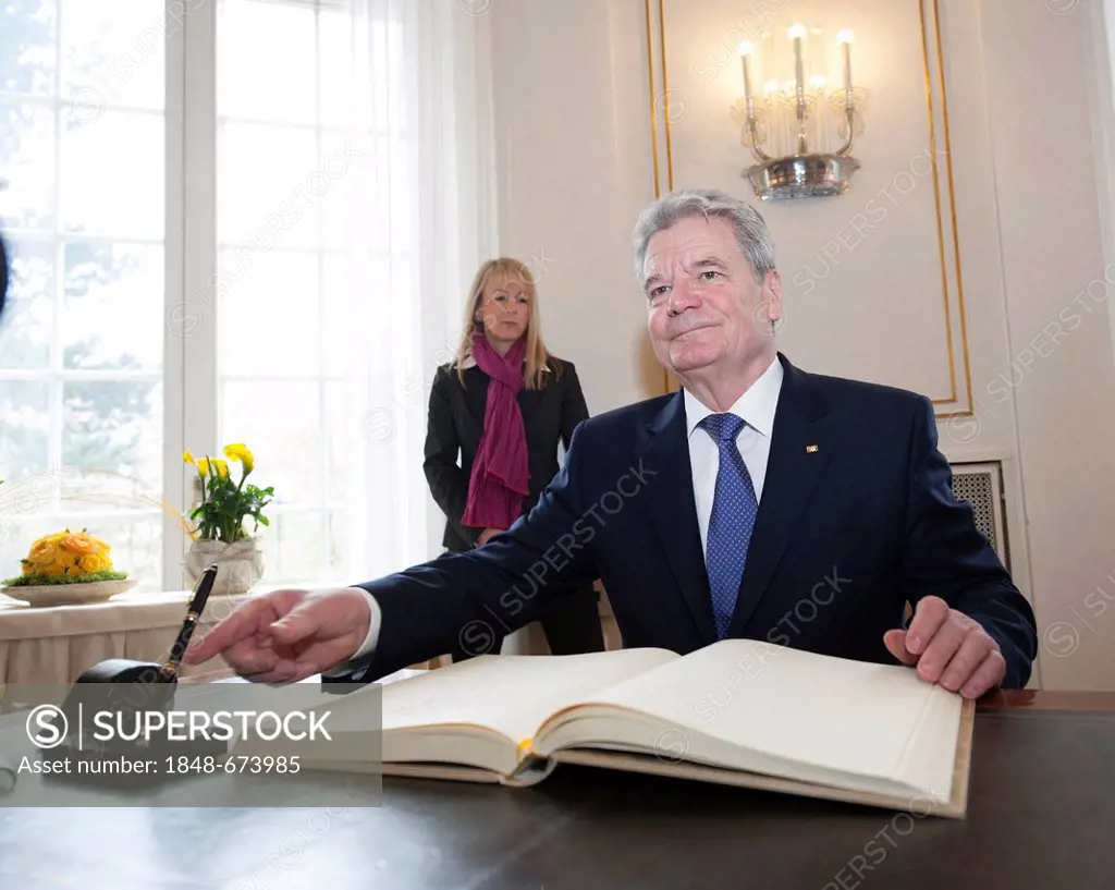 Federal President Joachim Gauck signing the visitors' book of the state of Baden-Wuerttemberg during his inaugural visit with his partner Daniela Scha...