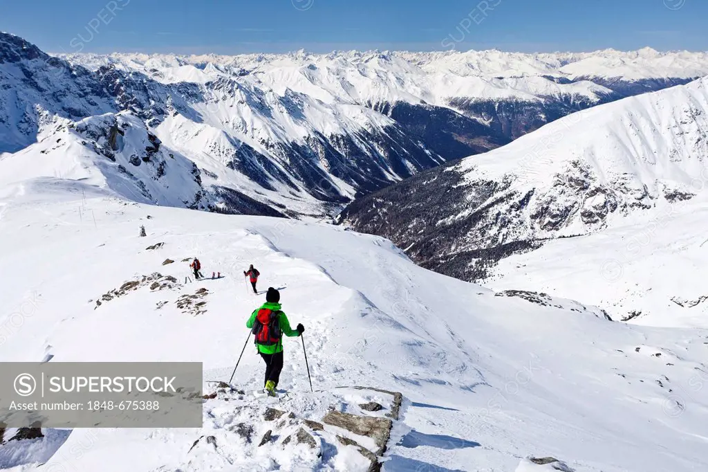 Cross-country skier during the descent from the rear of Schoentaufspitze Mountain, Solda in winter, looking over the Suldental Valley, Alto Adige, Ita...