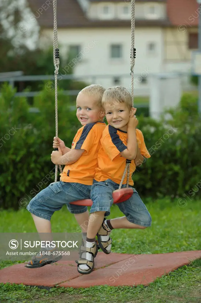 Two little boys, 3 and 4 years, on a swing
