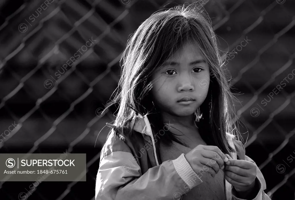 Sad girl in front of fence in Laos, Southeast Asia, Asia