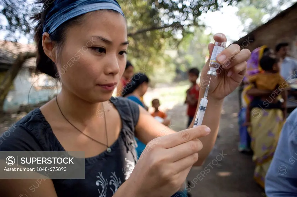 Employee of the German Doctors for Developing Countries preparing a syringe at a vaccination campaign, in Calcutta, Kolkata, West Bengal, India, Asia