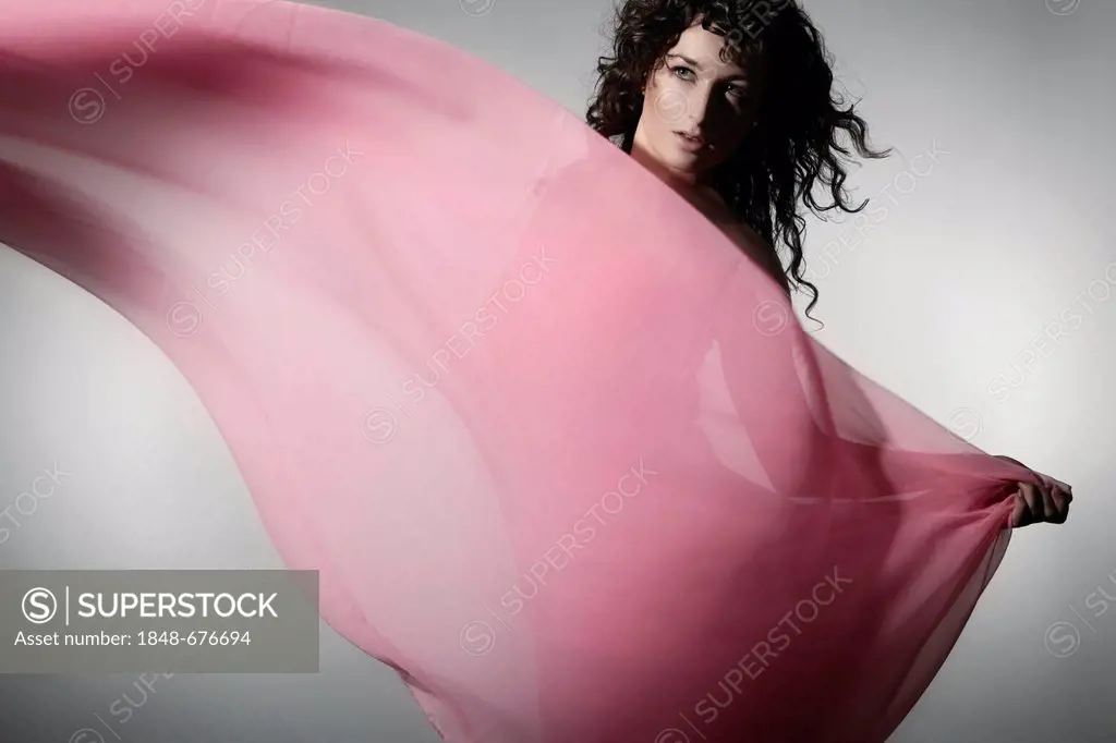Young woman wearing a pink dress with billowing fabric