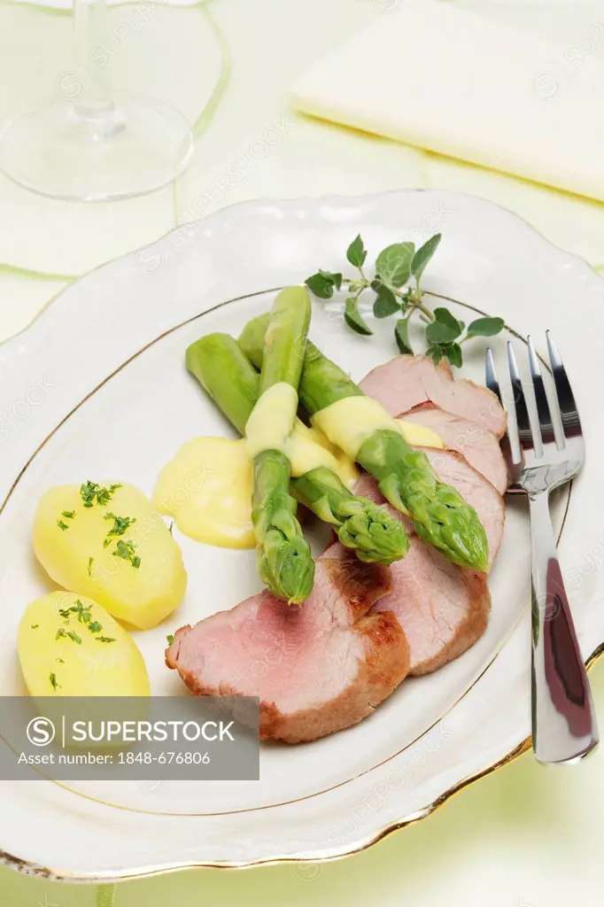 Roast of pork fillet with green asparagus, hollandaise sauce and young potatoes