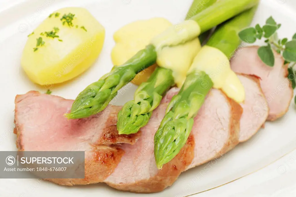 Roast of pork fillet with green asparagus, hollandaise sauce and young potatoes