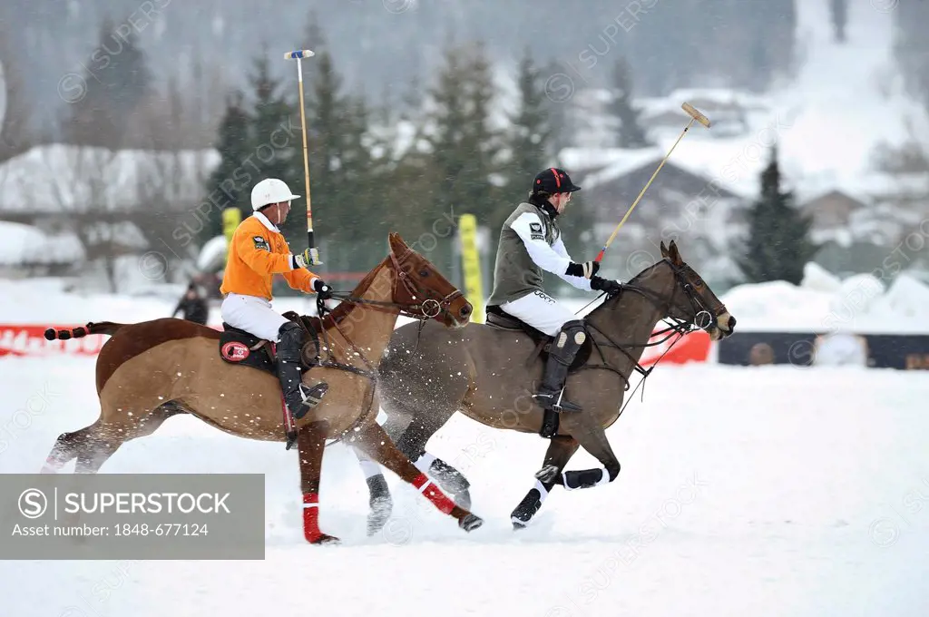 Two polo players galloping through the snow, Tarquin Southwell of team Hawker Beechkraft followed by Francisco Podesta of team Kitzbuehel, polo played...
