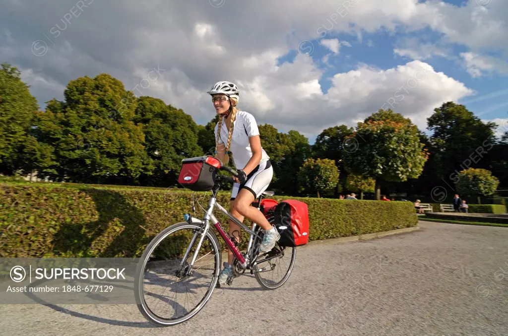 Woman riding her touring bike through the Hofgarten, Court Garden, Munich, Upper Bavaria, Bavaria, Germany, Europe