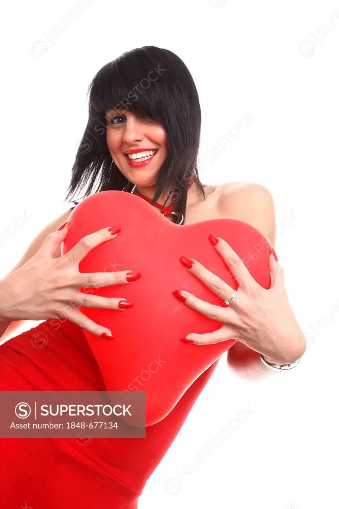 Smiling young woman holding a red heart-shaped balloon
