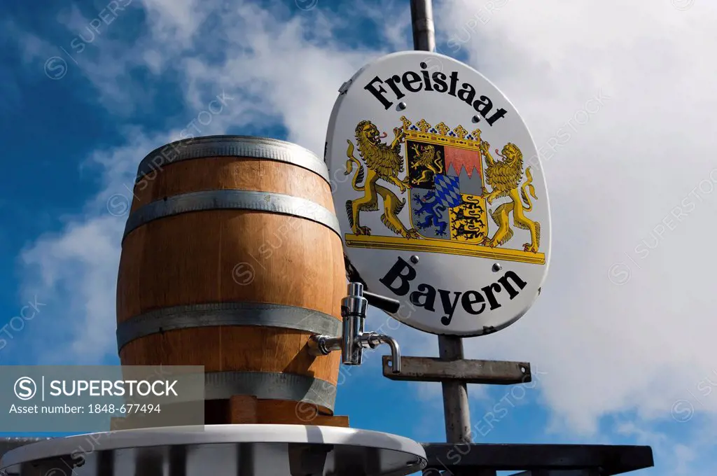 A barrel of beer standing in front of a border sign of the Freistaat Bayern or Free State of Bavaria, mountain station near the summit of Mt. Zugspitz...