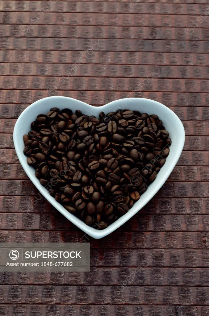 Coffee beans in a heart-shaped bowl made of porcelain