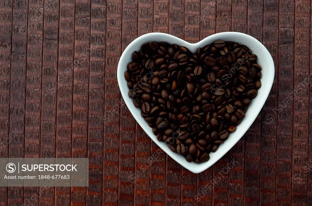 Coffee beans in a heart-shaped bowl made of porcelain