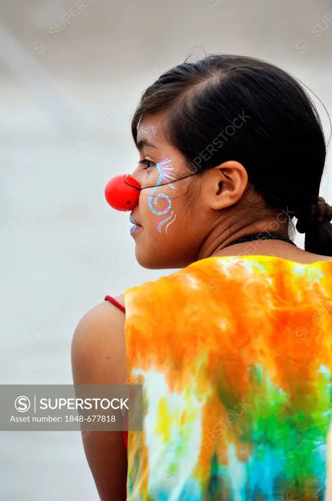 Girl with make-up wearing a red clown nose, Arena y Esteras project, teenagers marching through the streets dressed up as street artists, calling toge...