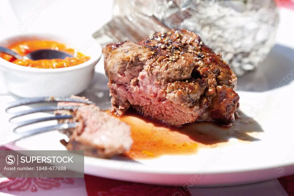 Argentinean fillet steak, baked potato with yogurt dip, and bowl with salsa dip