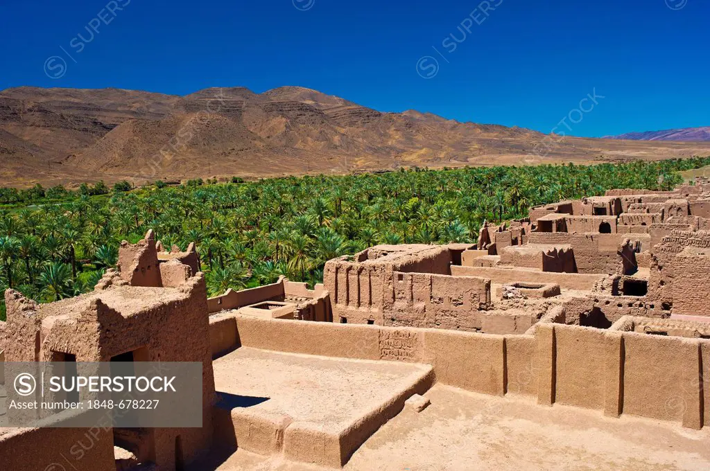 View from the roof of the Tamnougalte Kasbah, mud fortress, mud brick building of the Berber tribe, Tighremt, across the Draa Valley and a palm grove,...