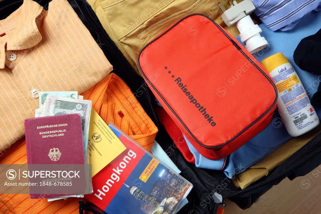 Holiday luggage, first-aid kit, passport, vaccination card, travel guide