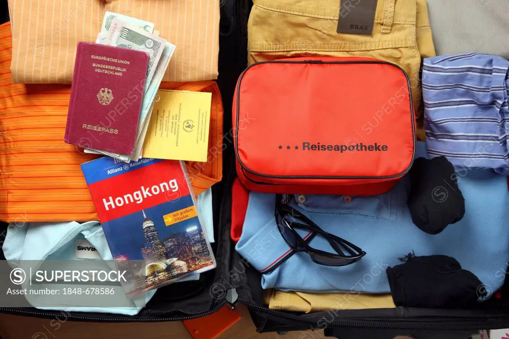 Holiday luggage, first-aid kit, passport, vaccination card, travel guide